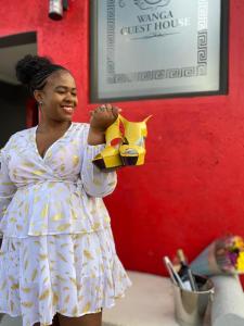 Una donna con un vestito che tiene un cavallo giocattolo di Executive Galaxy Guest House Nkowankowa a Nkowakowa Altre 152 foto