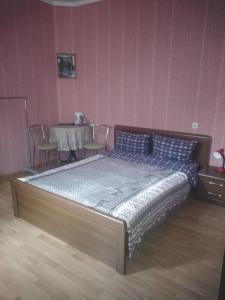 Ce lit se trouve dans un dortoir doté d'une table et de chaises. dans l'établissement Gostevoy Apartment, à Vinnytsia