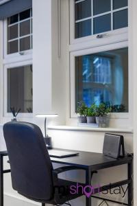 une chaise de bureau assise devant une fenêtre dans l'établissement The Residence Fitzrovia - Private One Bedroom Apartment With Own Entrance, à Londres
