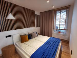 a bedroom with a bed with blue and yellow pillows at Apartamenty Wybrzeże Laguna in Ustronie Morskie