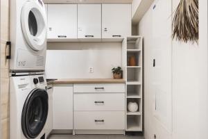 a white laundry room with a washer and dryer at Cozy villa in Bømlo in Bømlo