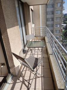 a balcony with a glass table and chairs on it at Apartamento 1 dormitorio estacionamiento Hermosa vista in Concepción