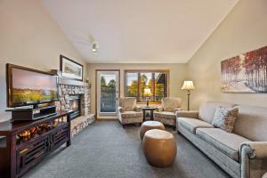 Evergreen Hill Condominiums في فيش كريك: غرفة معيشة مع تلفزيون ومدفأة