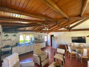 cocina con techos de madera, mesa y sillas en La Alamanda en Federación