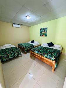 a room with two beds in a room at Hostal VILLAS DON PABLO LAS TABLAS in Las Tablas