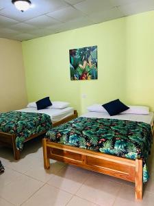 two beds sitting next to each other in a room at Hostal VILLAS DON PABLO LAS TABLAS in Las Tablas