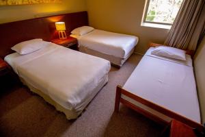 a hotel room with two beds and a window at Hotel Nevados de Chillan in Nevados de Chillan