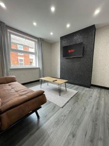 a living room with a couch and a table at Newly refurbished 3 bedroom/2bathroom entire house in Lincoln
