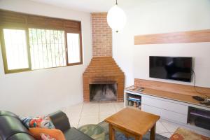 ein Wohnzimmer mit einem Sofa und einem Kamin in der Unterkunft Casa em Friburgo com piscina lareira suíte & quarto in Nova Friburgo