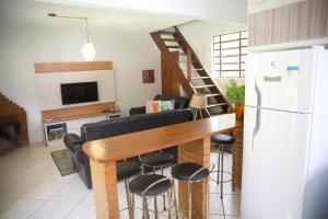 uma cozinha e sala de estar com mesa e cadeiras em Casa em Friburgo com piscina lareira suíte & quarto em Nova Friburgo