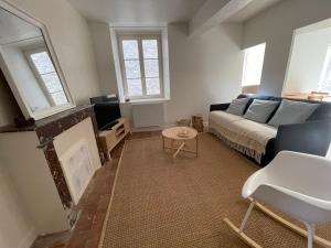 a living room with a couch and a fireplace at Nid bohème in Suèvres