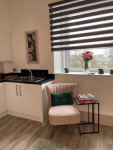 uma cozinha com uma cadeira, uma mesa e uma janela em Amazing Getaways - The Place for You with Free Parking em Aberdeen