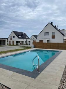 a large blue swimming pool in front of a house at Haus Nathalie in Trzęsacz