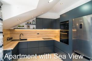 a kitchen with black cabinets and a stainless steel refrigerator at Apartments Budman in Dubrovnik