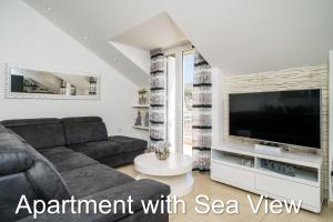 een woonkamer met een bank en een tv bij Apartments Budman in Dubrovnik