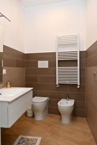 bagno con lavandino, servizi igienici e specchio di Olimpia Residence a Caserta
