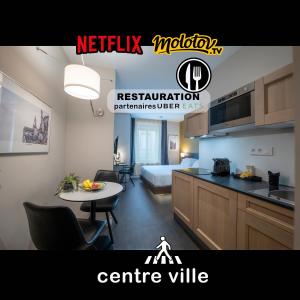 a kitchen and a living room with a bed and a table at Five Resort Cholet Centre in Cholet