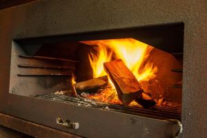 a fire inside of an oven with a log in it at B&B De Boskamp in Tegelen