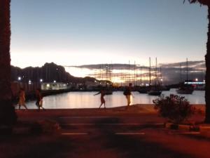 a group of people walking on a sidewalk near a body of water at Apart Laginha in Mindelo