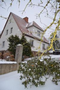 a white house with snow in front of it at Märchenherberge 7 Zwerge in Lichtenau