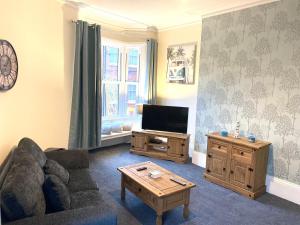 a living room with a couch and a tv at The Velvet Crab in Scarborough