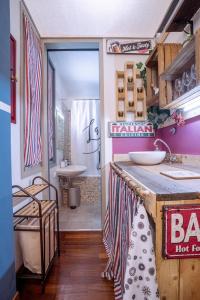 a bathroom with a counter with a sink and a tub at Maneki Artieri Bologna in Bologna