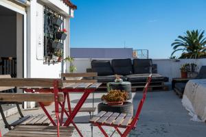 a patio with a table and chairs and a couch at Aguere Nest Hostel in Las Lagunas
