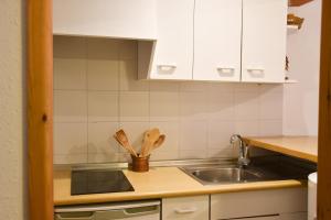 uma cozinha com armários brancos e um lavatório em ESTUDIO AVET - Perfecta ubicación em Pas de la Casa