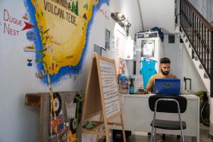 a man sitting at a desk with a laptop at Aguere Nest Hostel in La Laguna