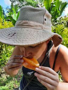 uma mulher com um chapéu a comer uma cenoura em La Muñequita Lodge 2 - culture & nature experience em Palmar Sur