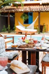 una mesa con platos de comida y bebidas. en Pousada Sabina en Barra Grande