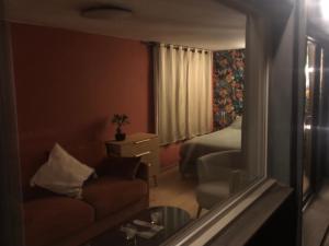 a hotel room with a couch and a bed and a mirror at L Antre Vous in Mons