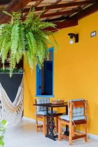 Pokój ze stołem i krzesłami oraz żółtą ścianą w obiekcie Pousada Sabina w mieście Barra Grande