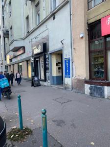 uma rua da cidade com pessoas andando em frente aos edifícios em PJ apartment em Budapeste