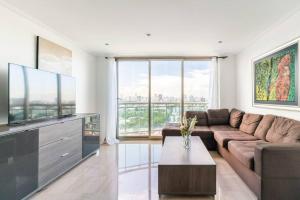 sala de estar con sofá y TV de pantalla plana en Luxurious 2BDR condo located in Prestigious Tower. en Santo Domingo