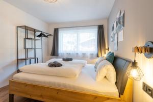 Un dormitorio con una cama grande con dos animales de peluche. en Apartment Waldherz en Wald im Pinzgau