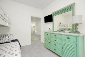 a bedroom with a green dresser with a mirror at Grace by the Sea in Myrtle Beach