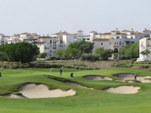 eine Gruppe von Menschen, die auf einem Golfplatz Golf spielen in der Unterkunft La Casa Rosita, Hacienda Riquelme Golf Resort Sucina in Murcia