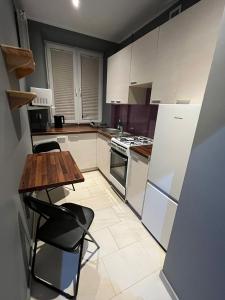 a kitchen with white cabinets and a table and chairs at Luxury apartaments Klimatyzacja 5 in Radom