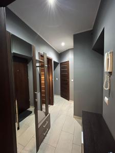 a room with a hallway with wooden doors at Luxury apartaments Klimatyzacja 5 in Radom