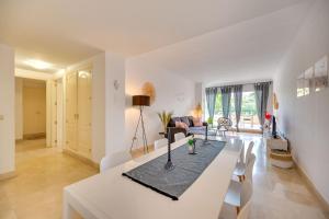 マルベーリャにあるLa Terraza Apartment Elviria Marbellaの白いリビングルーム(テーブル、椅子付)