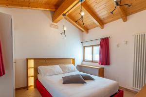 een slaapkamer met een bed in een kamer met houten plafonds bij For Rest in Madesimo