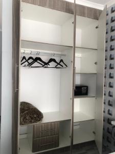 a closet with white walls and wooden shelving at Avrila Springs Hotel in Gaborone