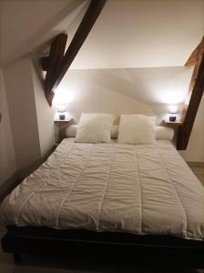 a bedroom with a large bed with two lamps on both sides at Studio en pleine campagne avec jardin privatif in Bournand