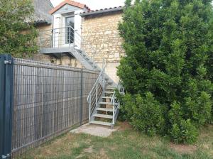 Una escalera que conduce a una casa con ventana en Studio en pleine campagne avec jardin privatif, en Bournand