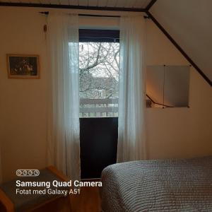 - une chambre avec un lit et une fenêtre dans l'établissement Naturnära dubbelrum B&B i Uppsala Ramstalund, à Uppsala