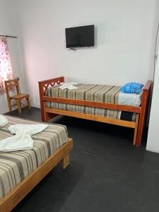 Una habitación con dos camas y un televisor de pantalla plana. en Departamento Sarmiento 1, en San Luis