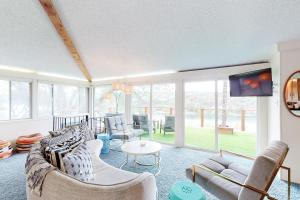 a living room with a couch and chairs and a tv at Casa del Lago in Marble Falls