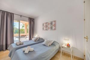 La Terraza Apartment Elviria Marbella في مربلة: غرفة نوم عليها سرير وفوط