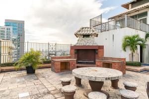 a patio with a brick grill with a table and stools at Luxurious 2BDR condo located in Prestigious Tower. in Santo Domingo
